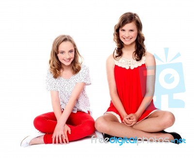 Teenage Sisters Sitting On Floor Stock Photo
