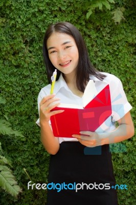 Thai Adult Student University Beautiful Girl Reading Red Book Stock Photo