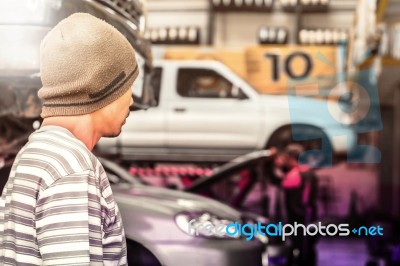 The Men Looking At  Mechanic In A Garage Stock Photo