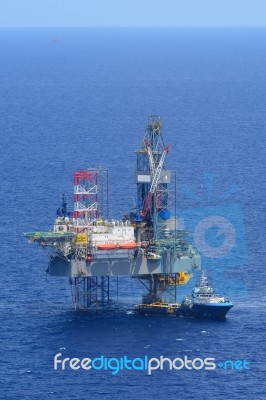 The Offshore Drilling Oil Rig And Supply Boat Side View Stock Photo
