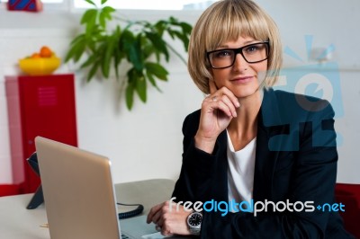 Thoughtful Business Lady Seated In Office Stock Photo