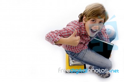 Top View Of Boy Sitting On Pile Of Books Stock Photo
