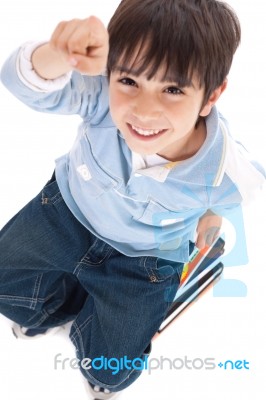 Top View Of Cute Kid Sitting On Books Stock Photo