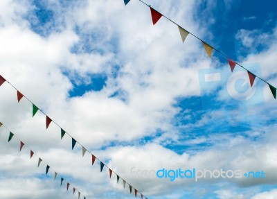 Triangle Flag Hanging On The Rope And Blue Sky Stock Photo
