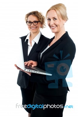 Two Corporate Women Working On Laptop Stock Photo
