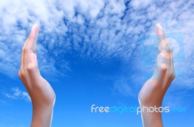 Two Hands Over Blue Sky Stock Photo