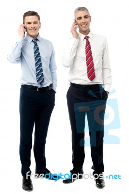 Two Male Executives Talking On Cellphone Stock Photo