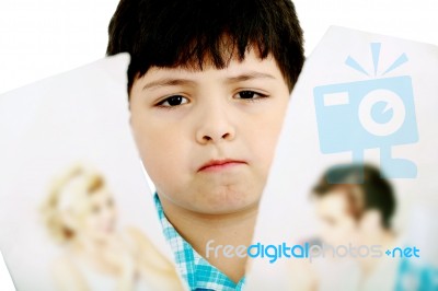 Upset Boy With Pictures Of Parents Stock Photo