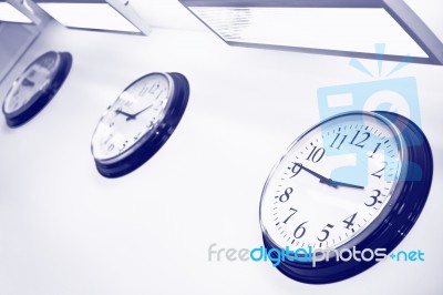 Wall Clocks Showing Different Time Stock Photo