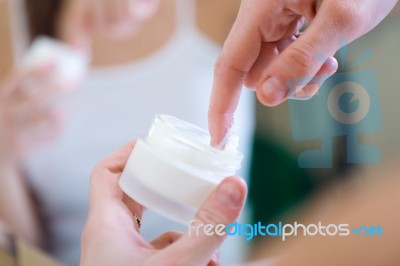 Woman Caring Of Her Skin Standing Near Mirror In The Bathroom Stock Photo