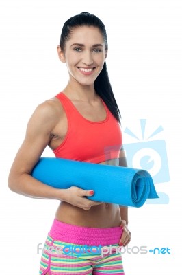 Woman Gym Instructor Holding Blue Mat Stock Photo