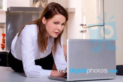 Woman In Kitchen With Laptop Stock Photo