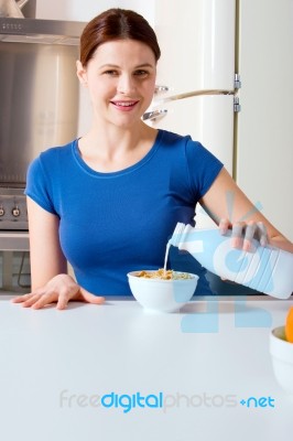 Woman Pouring Milk Into Cereal Stock Photo