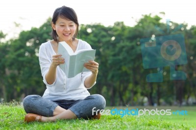 Woman Reading Book In Park Stock Photo