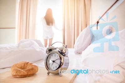 Woman Stretched In Bed Room After The Alarm Clock And Bread In T… Stock Photo