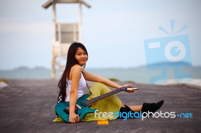 Woman With Guitar On The Road Stock Photo