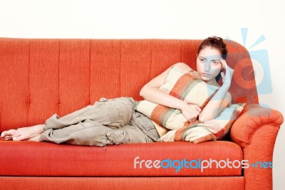 Woman With Headache On Sofa At Home Stock Photo