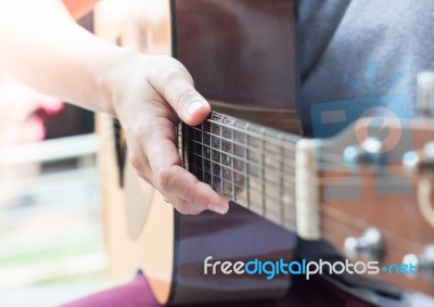 Woman's Hands Playing Acoustic Guitar Stock Photo