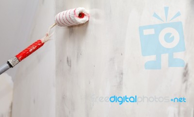 Worker Painting Wall With Glue Roller Closeup Stock Photo