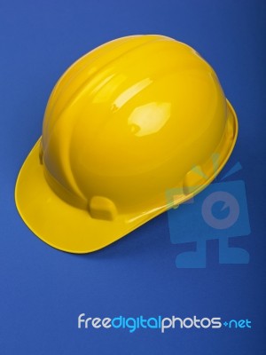Yellow Hard hat On Blue Stock Photo