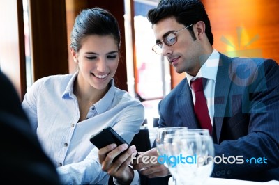 Young Business Partners Reviewing Work At Lunch Stock Photo