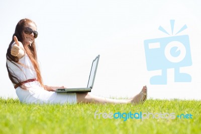 Young Female Sit In The Park And Using A Laptop Stock Photo
