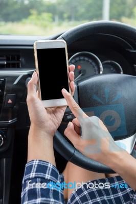 Young Female Driver Using Touch Screen Smartphone In A Car Stock Photo