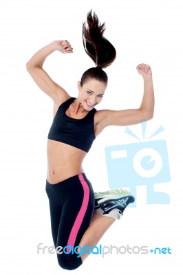 Young Girl In Sportswear Jumping With Joy Stock Photo