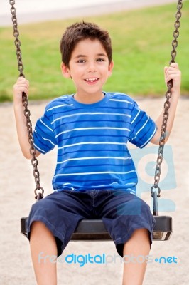 Young Kid Enjoying Swing Ride Stock Photo