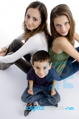 Young Kid Sitting With Teenagers Stock Photo
