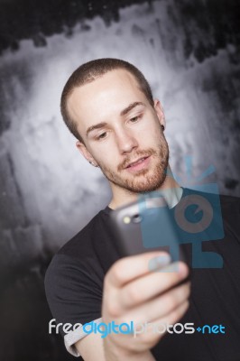 Young Male Holding Smartphone Stock Photo