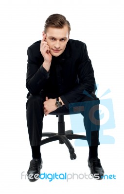Young Male Sitting On Chair Stock Photo