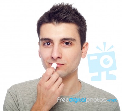 Young Man Applying Lip Balm Stock Photo