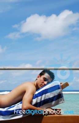 Young Man Sunbathing In A Maldives Resort Room Stock Photo