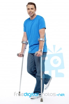 Young Man With Crutches Trying To Walk Stock Photo