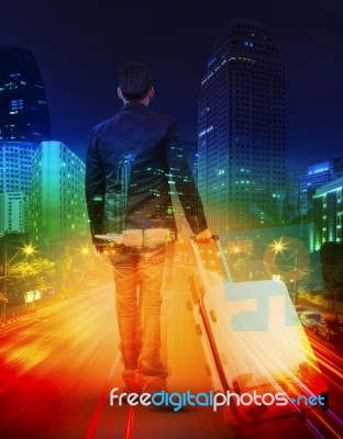 Young Man With Traveling Luggage Against  Lighting Of Urban Scen… Stock Photo