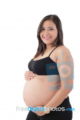 Young Pregnant Woman Smiling At Camera Against White Background Stock Photo