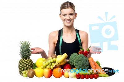 Young Smiling Girl Presenting Fresh Fruits Stock Photo