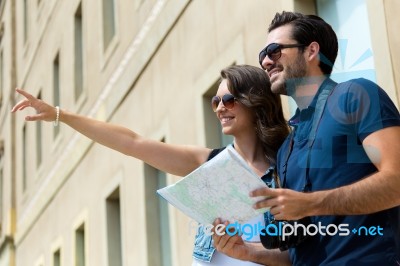 Young Tourist Couple Use Their Map And Pointing Where They Want Stock Photo