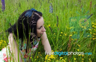 Young Woman Lying On The Grass Stock Photo