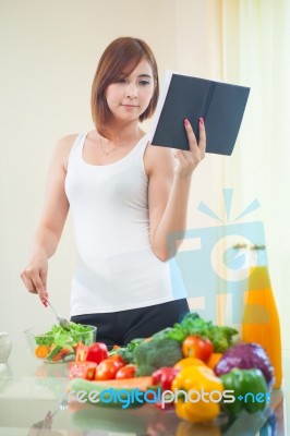 Young Woman Reads Cookbook Stock Photo