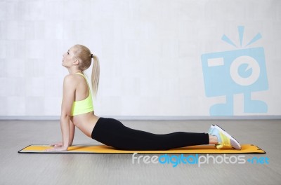 Young Woman Stretching Before Fitness Exercises On A Mat In A Gy… Stock Photo