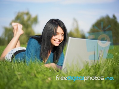 Young Woman Using Laptop In Park Stock Photo
