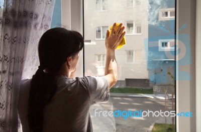 Young Woman Washing The Window Stock Photo
