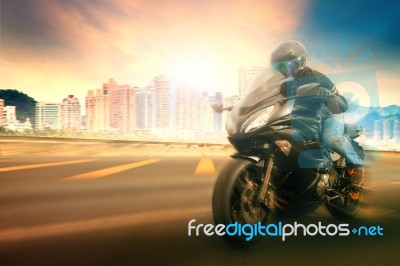 Younger Man Wearing Safety Helmet And Riding Suit  Biking Sport Motorcycle On Urban Road With Blurry Background Use For People Traveling And Sport Activity,leisure Stock Photo