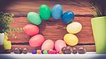 A Few Colorful Easter Eggs As A Flower Shape With Candies And Chocolate And Garden Plants Over Wood Background Happy Easter Stock Photo