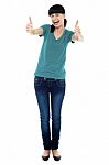 Amused Woman Gesturing Double Thumbs Up Stock Photo