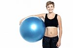 An Attractive Fit Lady Holding Blue Pilates Ball Stock Photo