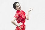 Asian Chinese Woman In Traditional Chinese Cheongsam Gesturing Stock Photo