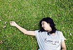 Asian Woman Laying In The Grass Stock Photo